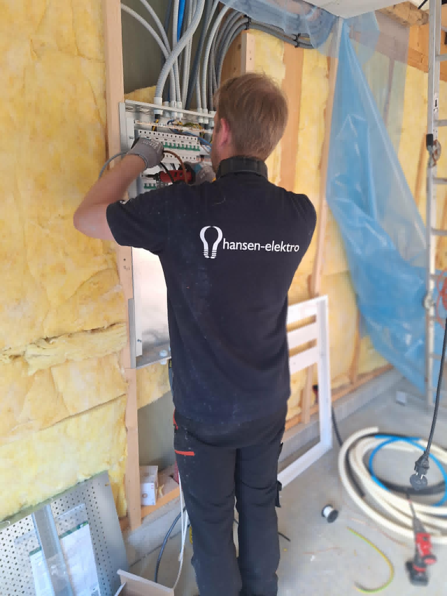 Montør fra Hansen-elektro arbeider i et sikringsskap under rehabilitering